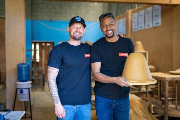 Wine To Water founder Doc Hendley (L) poses with Lenovo employee Fidele Mugisha after the successful fabrication of a ceramic water filter in the Dominican Republic.